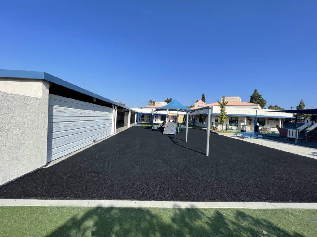 Black rubber surface beside a covered walkway between buildings
