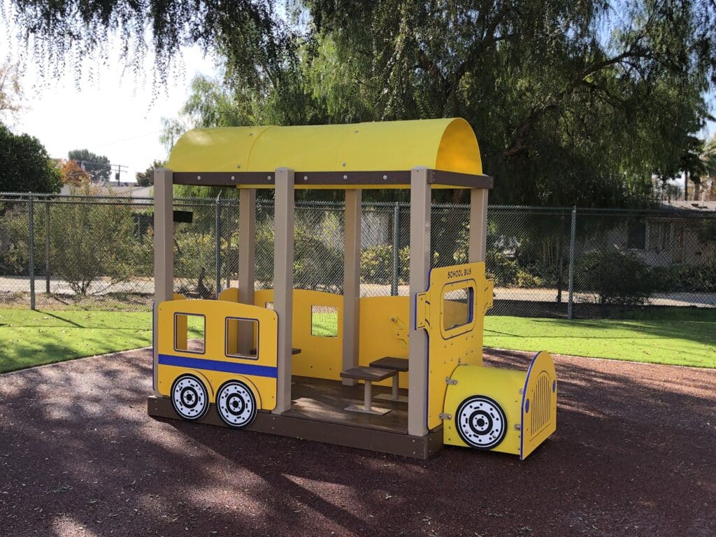 Yellow bus play structure on brown poured-in-place rubber