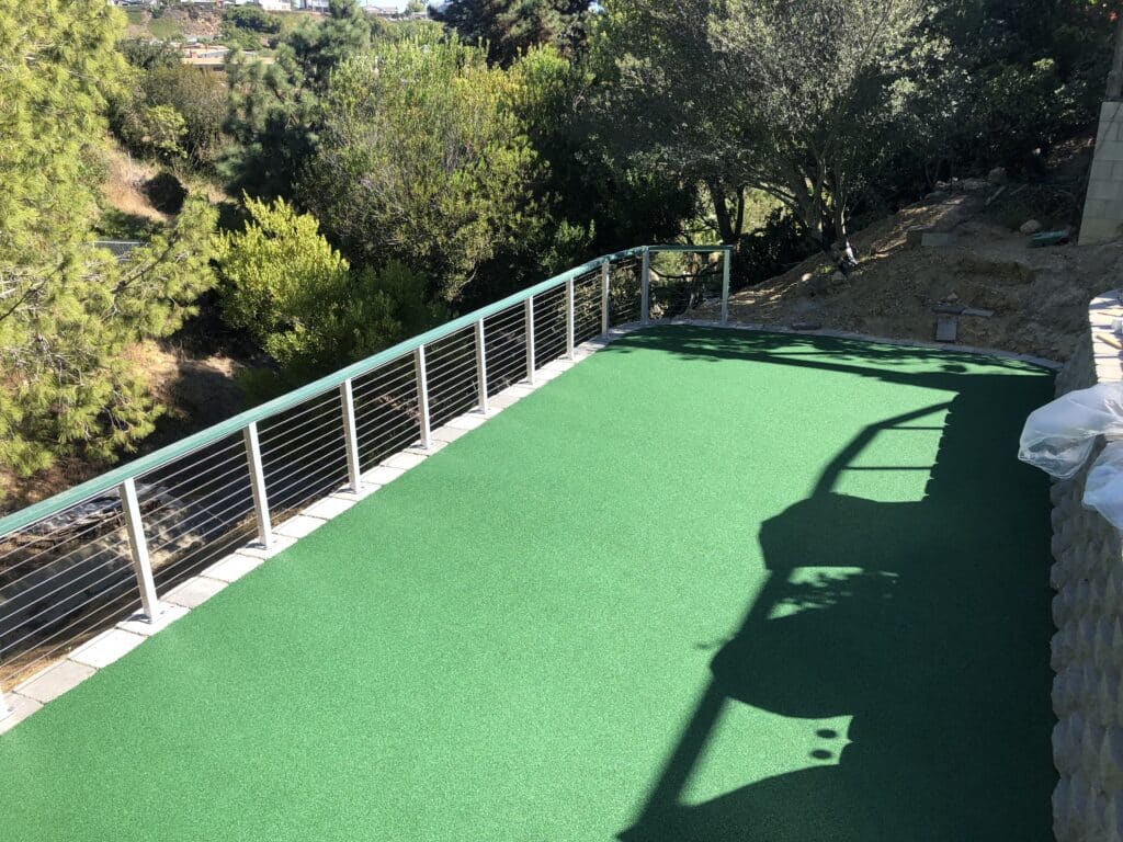Synthetic turf on a raised residential deck with cable railing