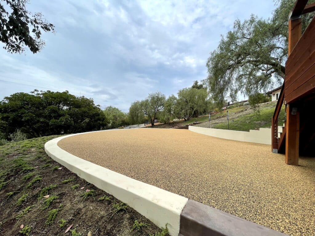 Curving porous rubber path edged with a concrete curb