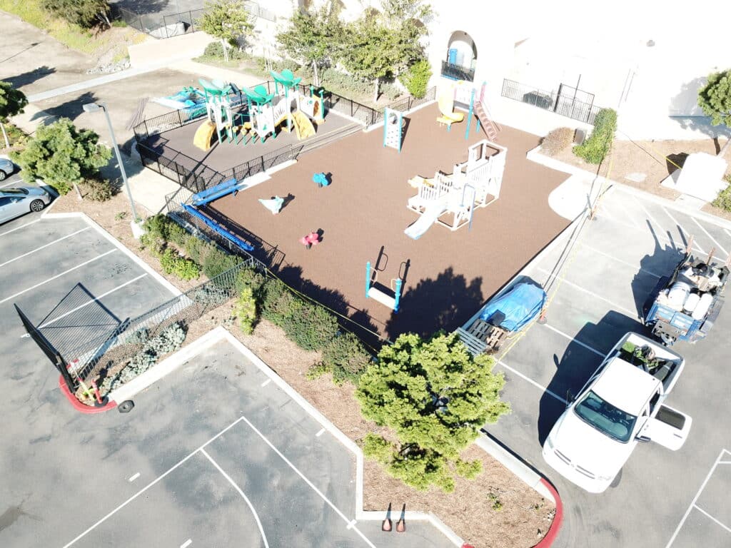 Aerial view of rubber surfacing beside a building and parking lot