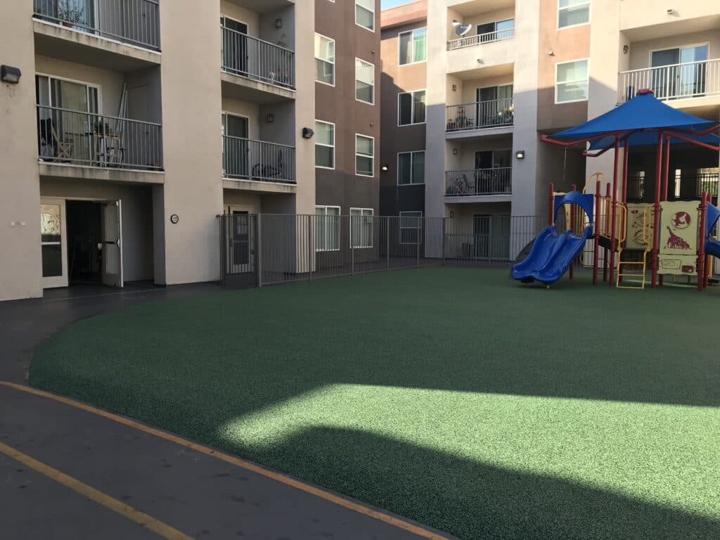 Synthetic turf courtyard with a play structure in an apartment community