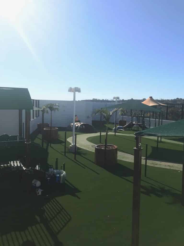 Tall shade structure over a turf play area
