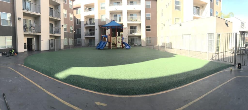Synthetic turf and a play structure in an apartment courtyard