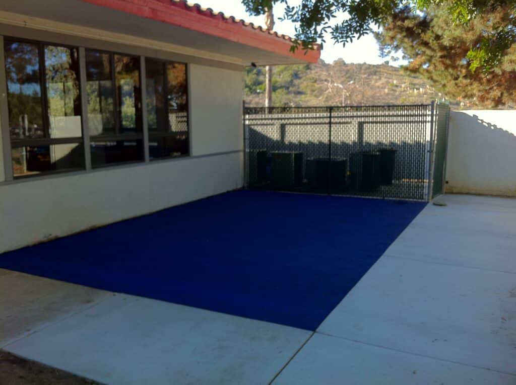Navy poured-in-place rubber pad beside a building