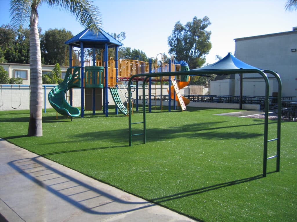 Playground on synthetic turf with a shade structure